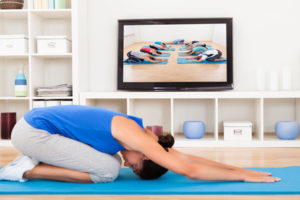 Female Doing Fitness Exercise In Front Of Television